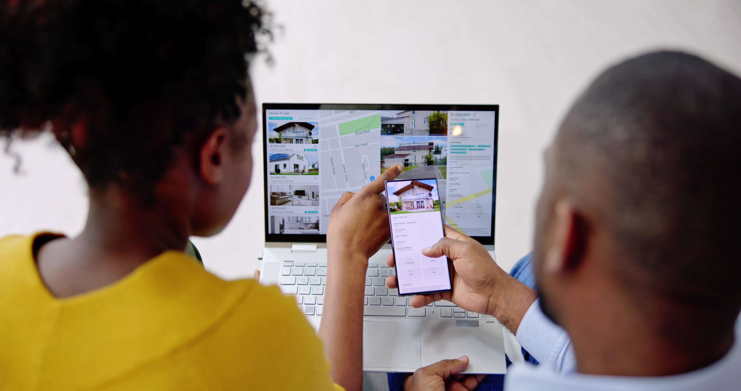 A couple comparing property listings while planning an investment purchase