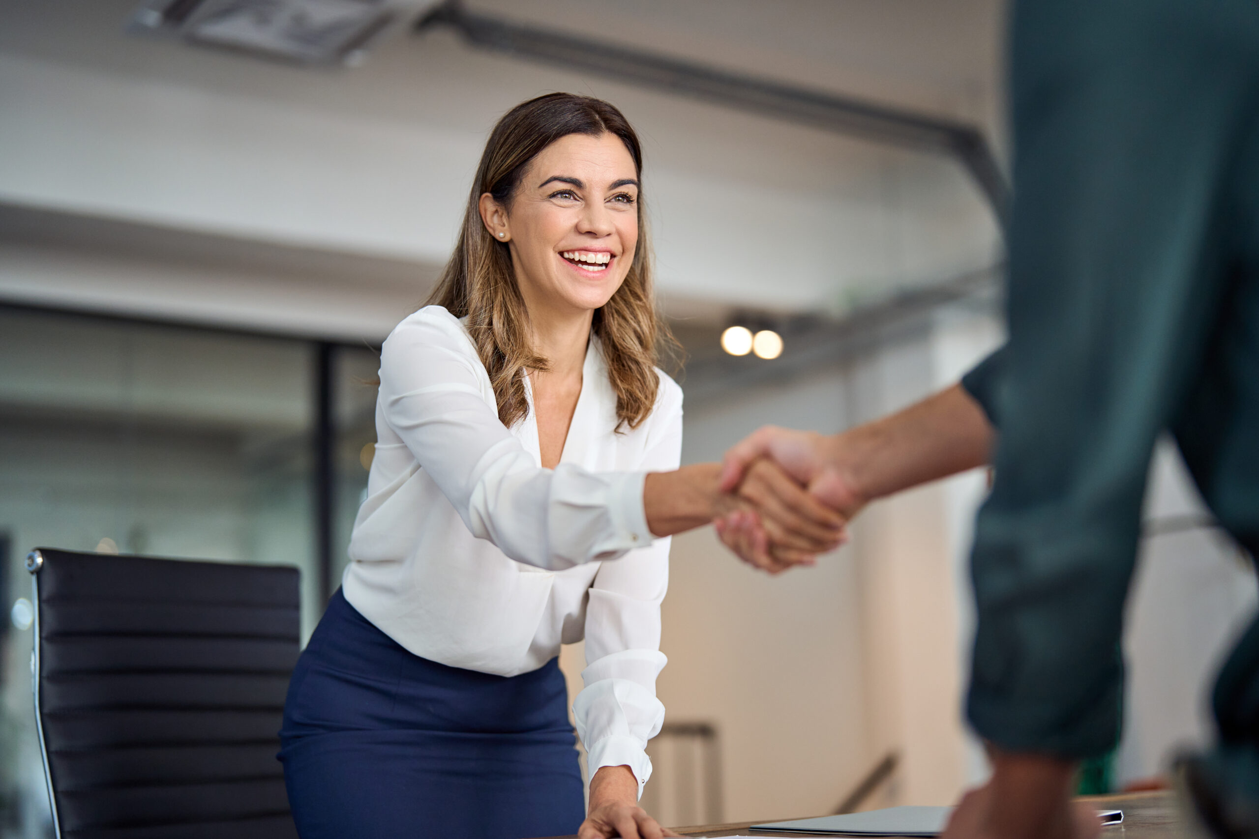 A wealth adviser welcoming a client to a meeting